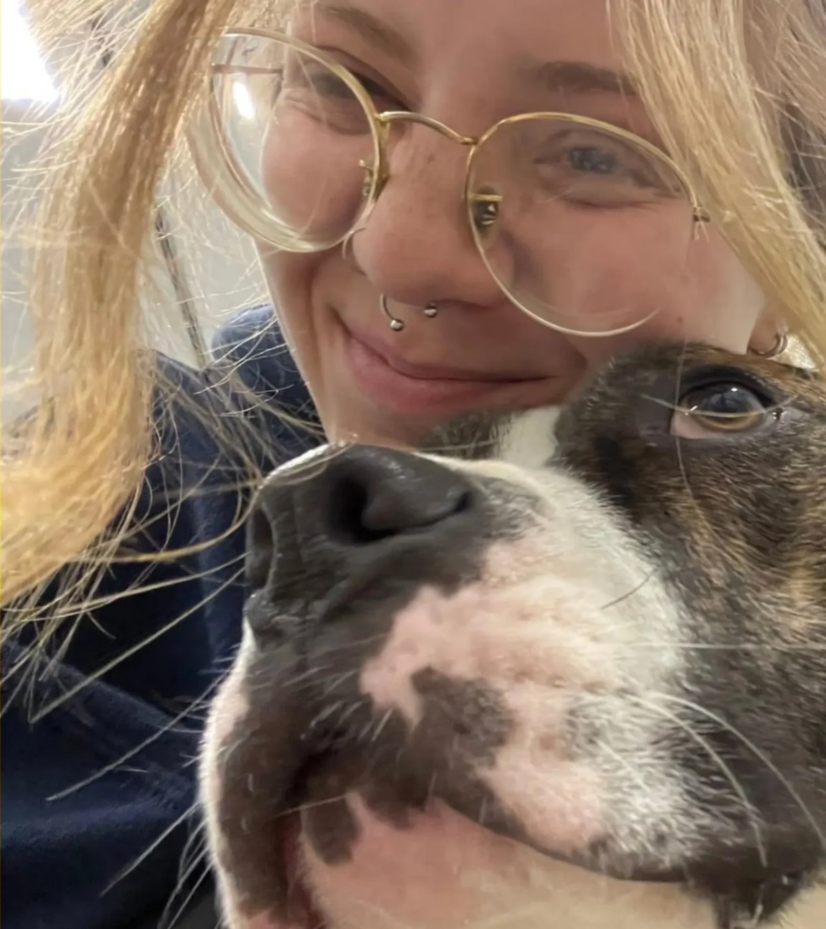 A Leader of the Pack team member getting an enthusiastic nose bump from a dog